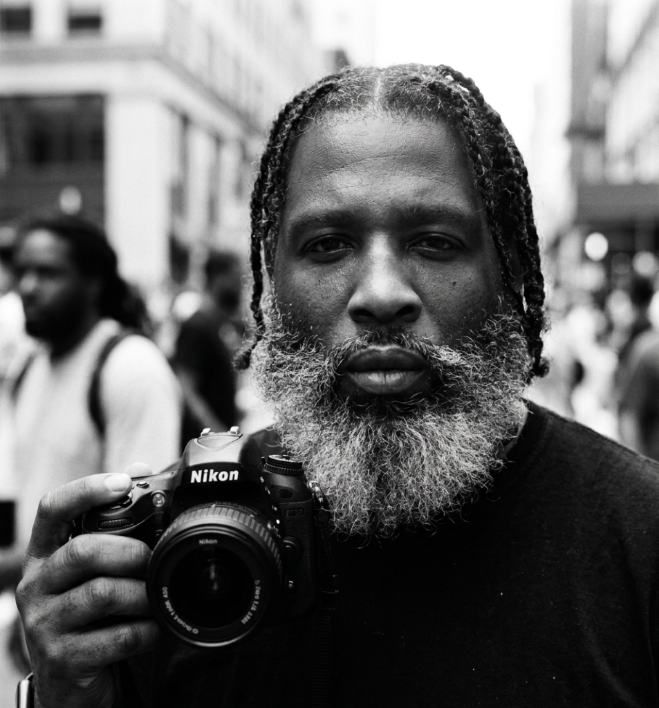 firefly gemini flash create a black and white picture with this guy holding a nikon camera in one hand 775387