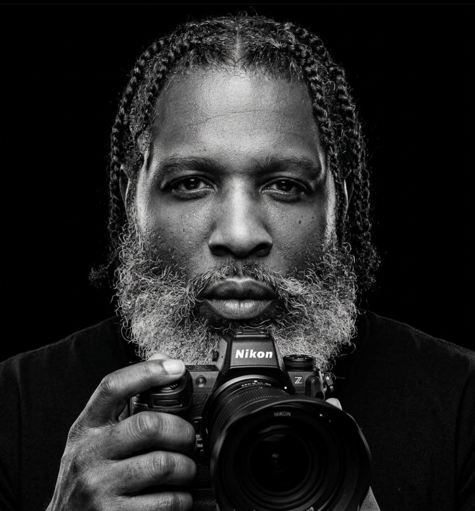 firefly gemini flash create a black and white picture with this guy holding a nikon mirrorless camera in o 775387